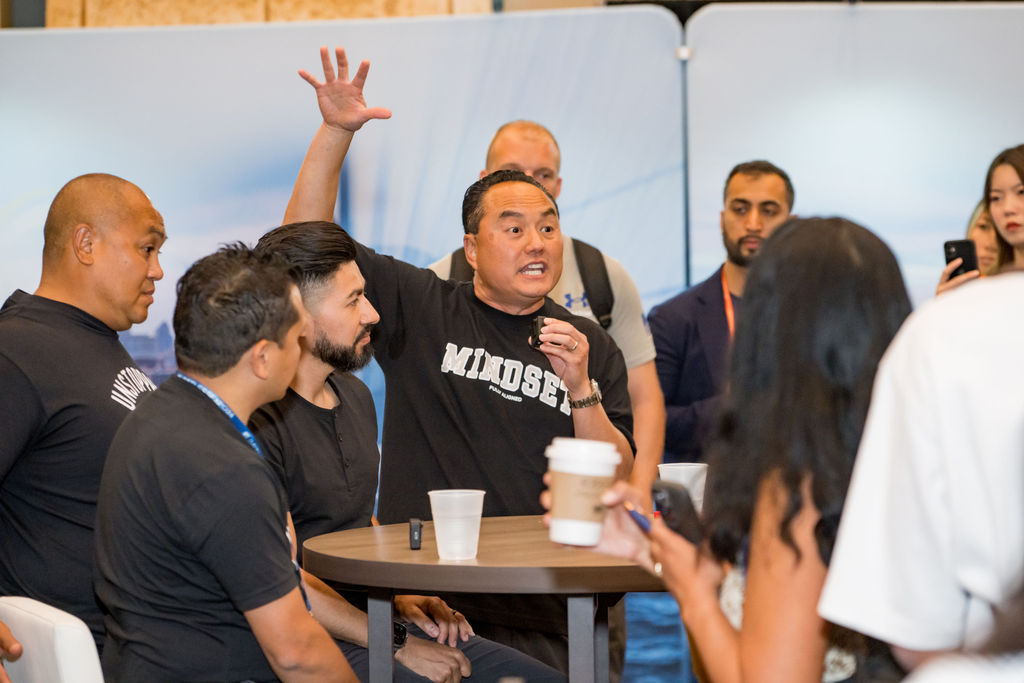 Attendee raising a hand during a roundtable discussion at the Limitless Expo exhibitor hall