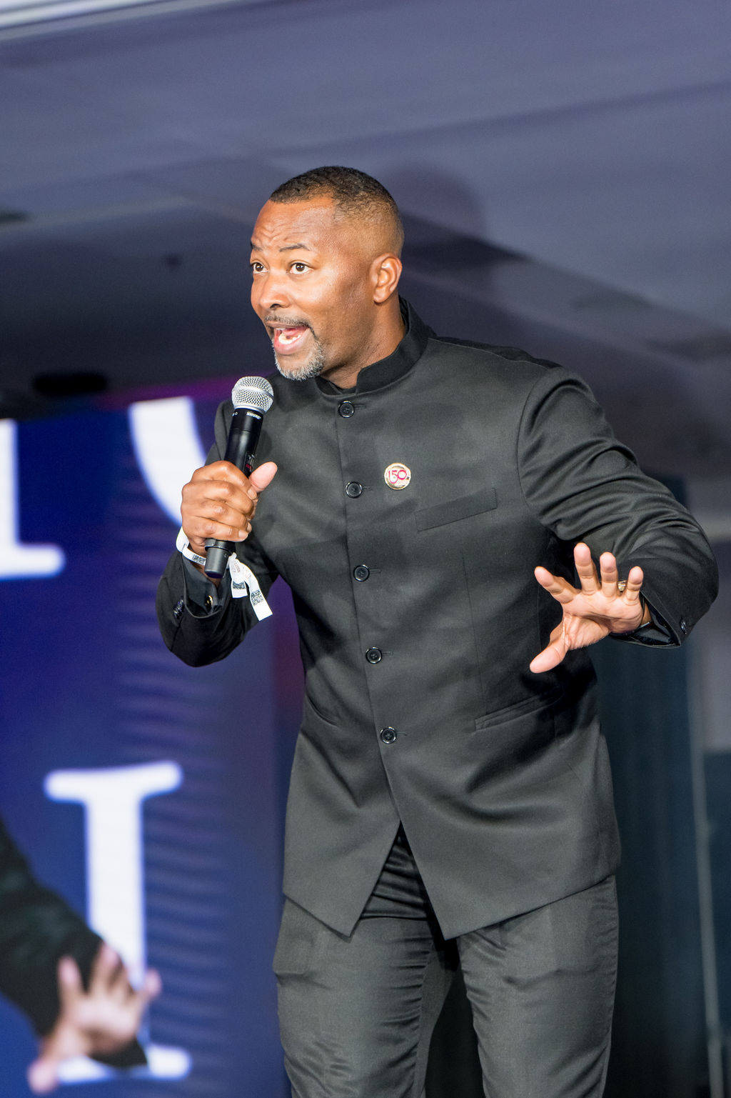 Emcee addressing the ballroom with a microphone