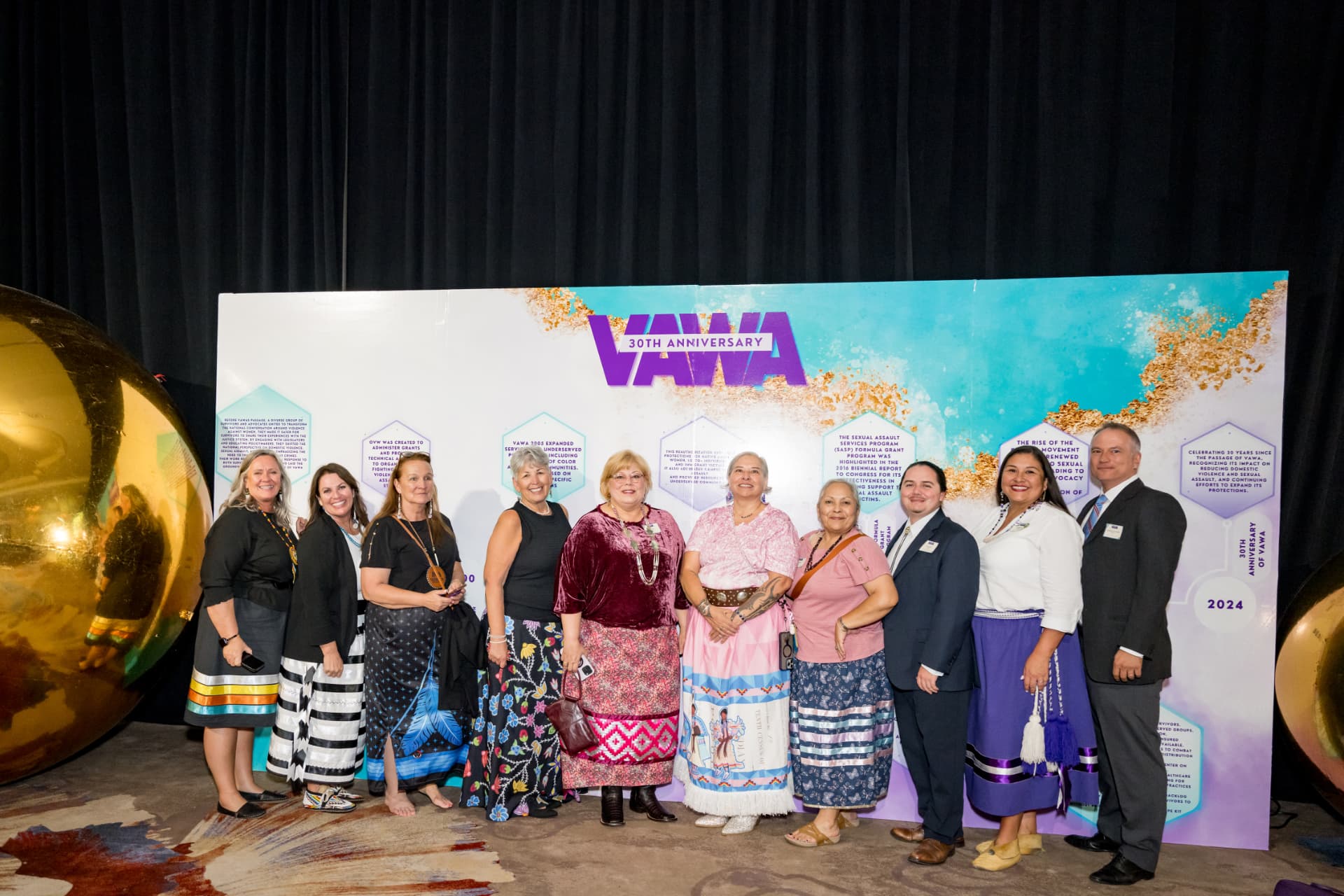Group photo of honorees in front of a VAWA 30th anniversary step-and-repeat backdrop