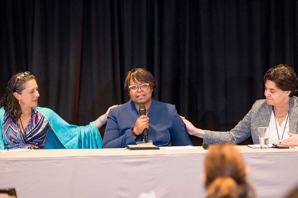 Three panelists seated at a table during a conference breakout session