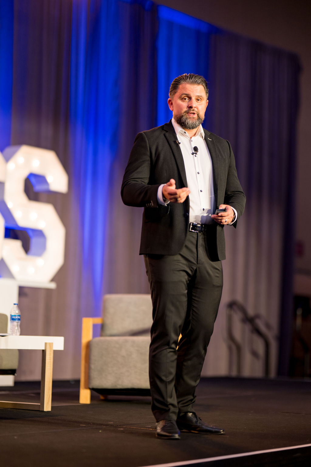 Speaker in a blazer presenting beside the Limitless marquee letters