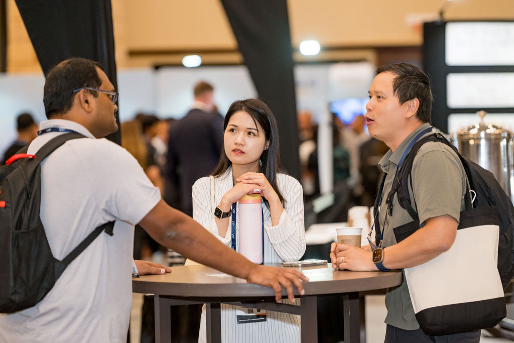 Attendees talking over coffee at a high-top table during Limitless Expo