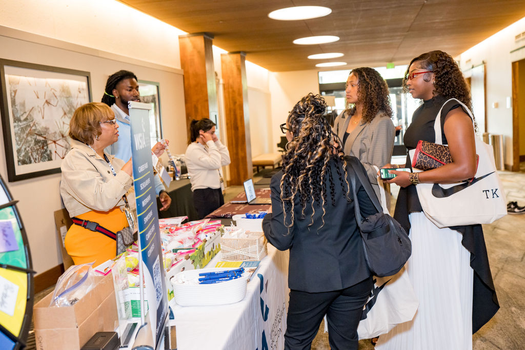 Attendees visiting the WSIAC sponsor table at the BSA Summit