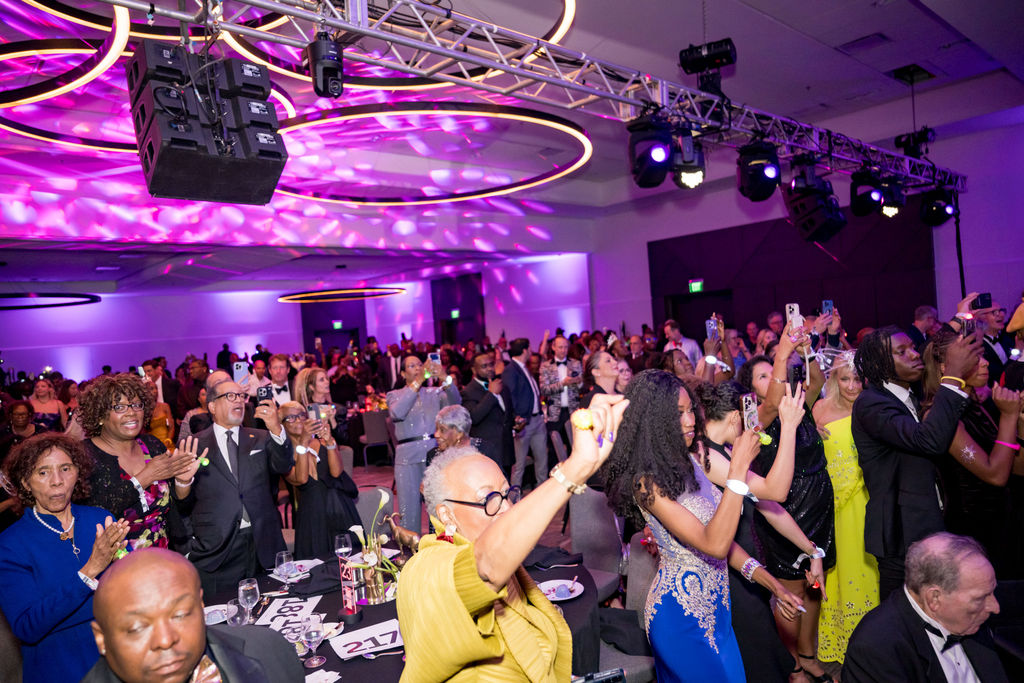 Guests applauding and filming from the ballroom floor