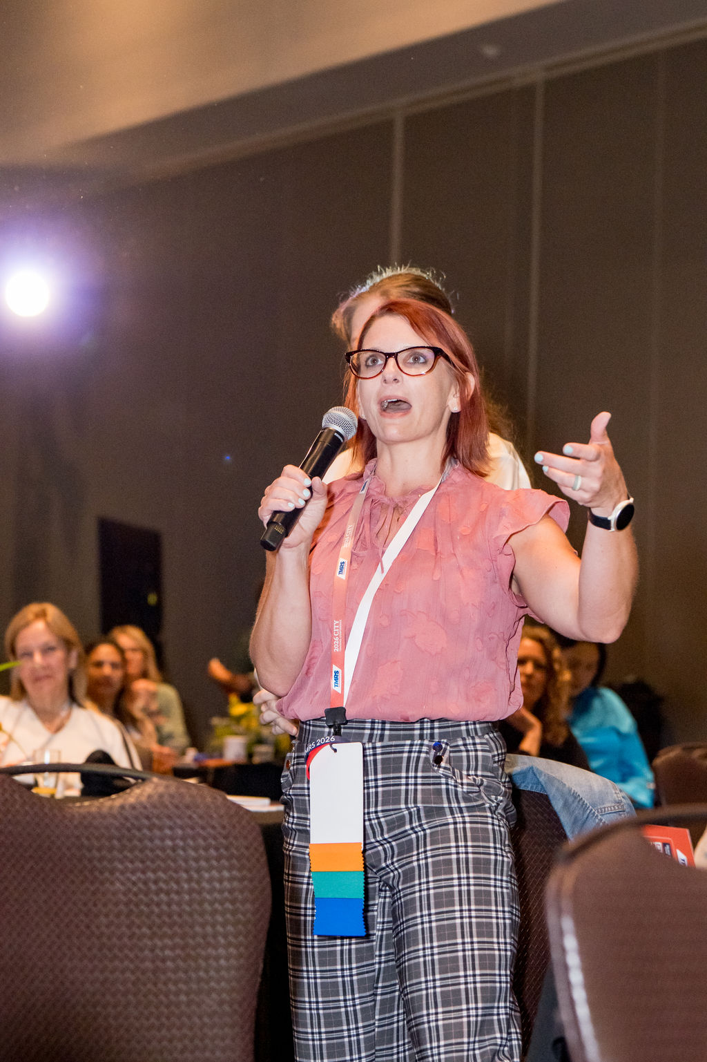 Attendee asking a question on the microphone during a TMRS session