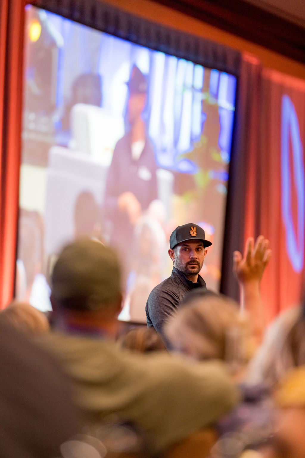 Attendee raising a hand to ask a question during a Limitless Expo session